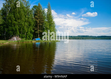 Blue simple voile sur la rive d'un lac quelque part dans les profondeurs de la Finlande, une belle journée d'été. Vacances sur le lac. Banque D'Images