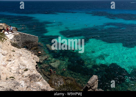 Favignana, Italie - Août 09, 2019 : la plage rocheuse de Bue Marino dans la magnifique île de Favignana dans une journée ensoleillée. Les gens sont de détente Banque D'Images
