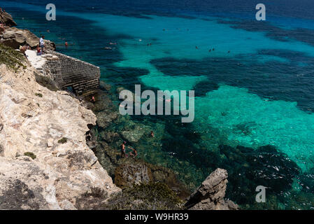 Favignana, Italie - Août 09, 2019 : la plage rocheuse de Bue Marino dans la magnifique île de Favignana dans une journée ensoleillée. Les gens sont de détente Banque D'Images