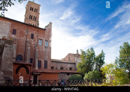 Basilica di Santa Francesca Romana parmi les arbres verts contre ciel bleu avec des nuages filandreux. Vieille ville de Rome, Italie. La journée ensoleillée d'automne Banque D'Images