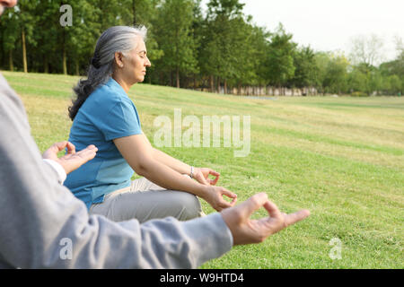 Old couple sitting in yoga pose Banque D'Images