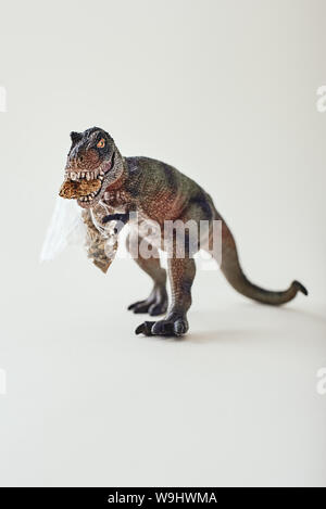 Jouet dinosaure en plastique isolé sur fond clair. Shot verticale Banque D'Images