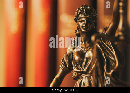 La figure de la Justice en laiton portant un bandeau holding up scales symbolique de la loi dans un close up the Moody de droit Banque D'Images