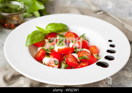 Salade savoureuse fraîche avec de la mozzarella, tomates cerises et de feuilles de basilic Banque D'Images