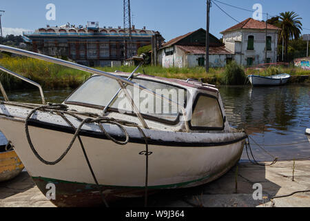 Un petit bateau à moteur, amarré sur le côté d'une rivière à Cáceres, Espagne. Banque D'Images