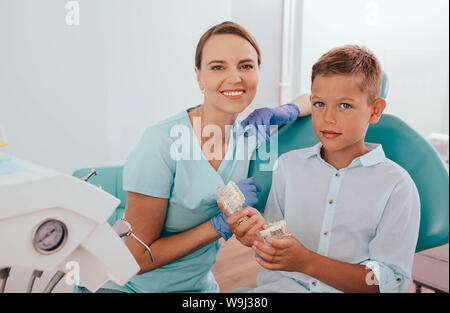 Petit garçon l'éducation sur les soins des dents de son dentiste. Banque D'Images