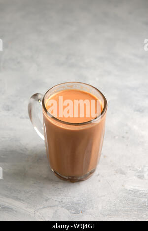 Thé au lait dans une tasse ou populairement connu comme Teh Tarik sur fond blanc, vue d'un côté Banque D'Images