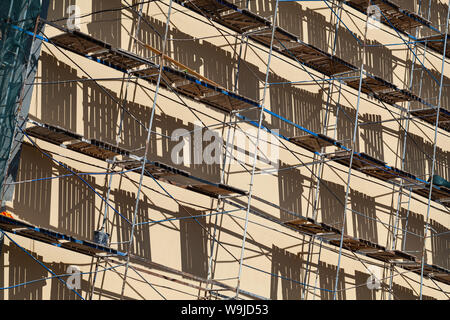 Vieux Mur de la maison est en rénovation, fragment de façade avec des structures d'échafaudage Banque D'Images