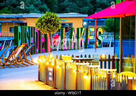 Soirée sur la promenade à Rushden Lacs Shopping Centre, le Northamptonshire, Angleterre, où vous pourrez dîner en plein air avec vue sur l'eau Banque D'Images