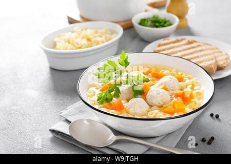 Bouillon de poulet chaud, bouillon aux boulettes de viande, les carottes, les pâtes et le persil frais Banque D'Images