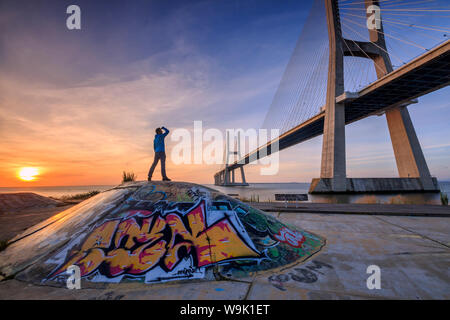 Un touriste admire le majestueux pont Vasco da Gama sur le Tage, Parque das Nações, Lisbonne, Portugal, Europe Banque D'Images