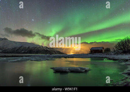 Le Northern Lights illumine la cabane en bois, Svensby, Alpes de Lyngen, Troms, Laponie, Finlande, Scandinavie, Europe Banque D'Images