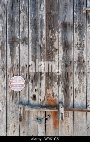 Un pas de parking Sign sur une vieille porte en bois patiné en Dordogne, France Banque D'Images