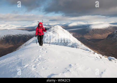 Une femme approche walker le sommet de Stob Buchaille Etive Beag Dubh sur sur un jour d'hiver, Highlands, Ecosse, Royaume-Uni, Europe Banque D'Images