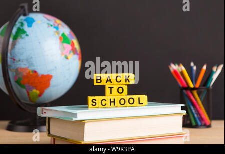 World globe avec des fournitures scolaires et du texte Banque D'Images