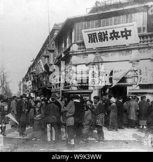 [ 1900 - Japon ] Journal Ginza - une petite foule présente les dernières nouvelles sur la guerre russo-japonaise en face de l'office de la Ginza Chuo Shimbun (中央新聞) en 1904 (ère Meiji) 37. Au-dessus de l'entrée lit 'Special Edition' (号外発行). Le Chuo Tokyo Shimbun était un quotidien publié à partir de 1891 (24) et Meiji Showa 15 (1940). 20e siècle stéréogramme vintage. Banque D'Images