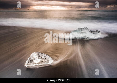 Les icebergs au lever du soleil sur la plage de Jokulsarlon, une plage de sable volcanique noir dans le sud-est de l'Islande, Islande, régions polaires Banque D'Images