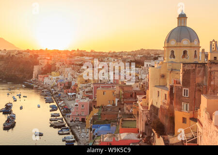 Marina Corricella au coucher du soleil, village de pêcheurs, des maisons de pêcheurs, des bateaux et de l'église, île de Procida, dans la baie de Naples, Campanie, Italie, Europe Banque D'Images