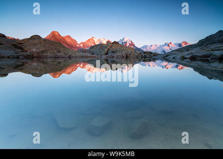 Sommets enneigés reflétée dans le lac au coucher du soleil, la Fuorcla Surlej,, Saint Moritz, Canton des Grisons, Engadine, Suisse, Europe Banque D'Images