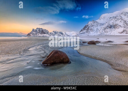 La première lumière de l'aube éclaire les rochers façonnés par le vent et le froid de la mer Uttakleiv, îles Lofoten, Norvège, de l'Arctique, Scandinavie, Europe Banque D'Images