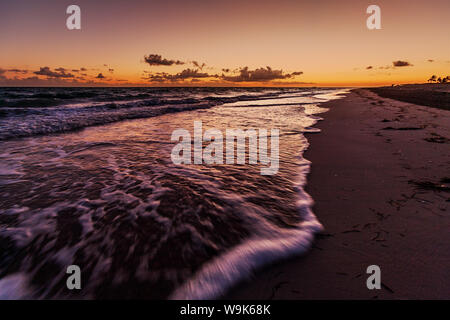 Rouleau de vagues sur la plage tandis que l'aube au-delà de la péninsule de Hicacos et longue étendue de plage à Varadero, Cuba, Antilles, Caraïbes Banque D'Images