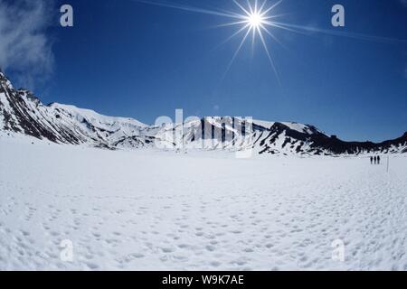 La fin de l'hiver, les randonneurs sur névé en Afrique du cratère sur Tongariro Crossing, Parc National de Tongariro, l'UNESCO, de l'Auckland, île du Nord, Nouvelle-Zélande Banque D'Images