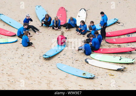 Une leçon de surf sur la grande plage de l'Ouest à Newquay en Cornouailles. Banque D'Images