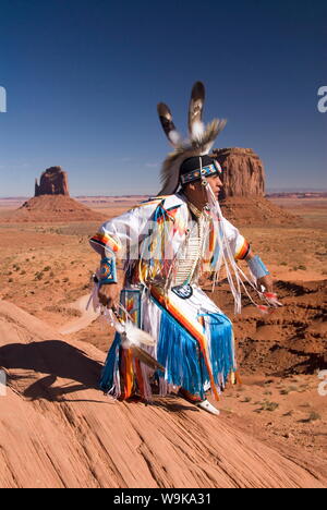 Homme Navajo en costume traditionnel dansant, avec Merrick Butte et East Mitten Butte, Monument Valley Navajo Tribal Park, Utah, USA Banque D'Images