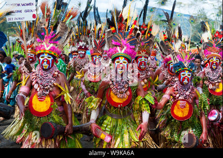Habillés de couleurs vives et le visage peint les tribus locales pour célébrer la traditionnelle chanter chanter dans les hautes terres de la Papouasie-Nouvelle-Guinée, du Pacifique Banque D'Images