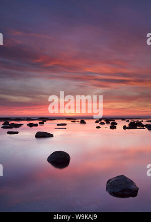 Des rochers et de réflexions dans la mer au lever du soleil, Saltwick Bay, Yorkshire, Angleterre, Royaume-Uni, Europe Banque D'Images