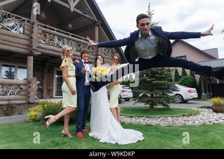 Des nouveaux mariés avec des demoiselles et petit ami s'amuser lors de la cérémonie du mariage à la villa Banque D'Images