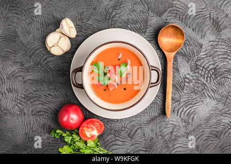 Soupe froide espagnole gaspacho de tomates, poivre, ail et fines herbes dans une plaque sombre sur fond noir Vue supérieure avec copyspace. La nourriture végétarienne Banque D'Images