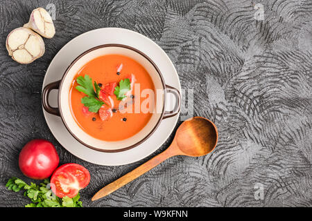 Soupe froide espagnole gaspacho de tomates, poivre, ail et fines herbes dans une plaque sombre sur fond noir Vue supérieure avec copyspace. La nourriture végétarienne Banque D'Images