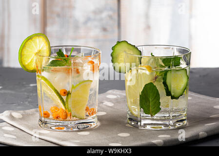 Libre de boissons rafraîchissantes au citron, citron vert, concombre, l'argousier gris sur fond de bois Banque D'Images