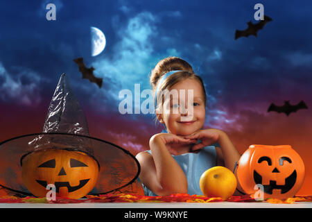 Célébration de l'Halloween. Charmante petite fille dans un costume de princesse sur l'arrière-plan de la soirée lune ciel. Banque D'Images