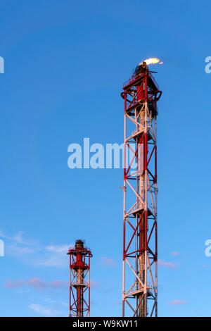 Torchère industrielle pour la combustion des gaz de pétrole associés contre le fond de ciel Banque D'Images