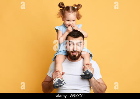 Moment inoubliable avec adorable papa. la photo en gros. fond jaune isolé. studio shot. Banque D'Images
