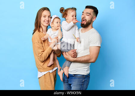 Petite fille traiter son père avec Lucette, les enfants s'amusant avec les parents isolés sur fond bleu. Banque D'Images