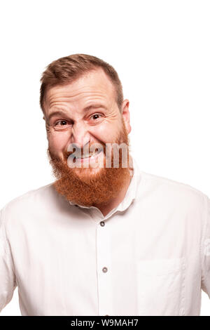 Portrait d'un jeune homme roux, chubby, dans une chemise blanche faisant des grimaces à l'appareil photo, isolé sur fond blanc Banque D'Images