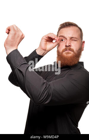 Portrait d'un jeune homme roux, chubby, dans une chemise noire faisant des grimaces à l'appareil photo, isolé sur fond blanc Banque D'Images