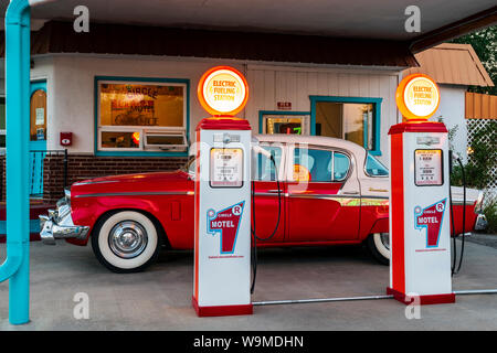 Crépuscule sur 1955 Studebaker President classic voiture garée en face de pompes à essence anciennes converties en chargeurs de voiture électrique ; l'Circle R Motel ; Salida Banque D'Images