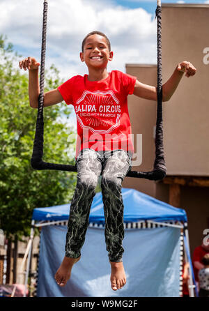 Young African American boy sur scène ; trapèze Salida Circus summer camp finale ; Salida, Colorado, USA Banque D'Images