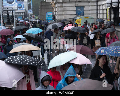 Londres, Royaume-Uni. 14 août, 2019. Les touristes ne sont pas découragés par la pluie qu'on voit ici sur la rive sud de Londres près de London Eye, ce début de soirée. Crédit : Joe Keurig / Alamy News Banque D'Images