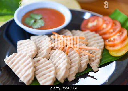 Saucisse de porc blanc Asie - Mooyor in Thai / saucisse de porc fermenté tranche sur plaque avec de la sauce tomate Banque D'Images