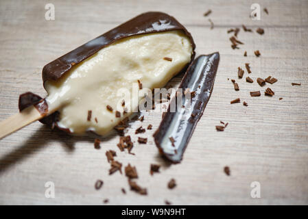 La fonte des glaces et de popsicle stick et lolly dessert sucré / glace vanille crème chocolat sur fond de bois couverte , selective focus Banque D'Images