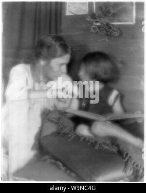 Béatrice Baxter Ruyl en blanc et Ruth Ruyl en short sur la table, holding open book Banque D'Images