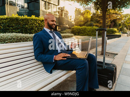 Indian businessman holding laptop notebook portant costume bleu près de l'office de tourisme Banque D'Images