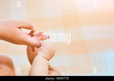 Enfant nouveau-né est titulaire d'un mother's finger, close-up concept l'amour. Mains de la mère et l'enfant libre. Toucher le moment agréable. Concept de soutien, d'espoir, Banque D'Images