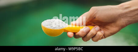 Tenir la main Chlorinefor l'eau dans la piscine BANNER, format long Banque D'Images