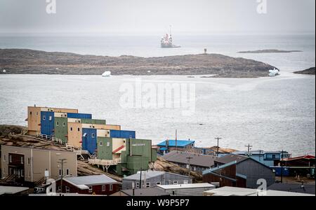 Iqaluit, Canada. 14Th Aug 2019. Un cargo ancres au large de la ville d'Iqaluit dans le nord du Canada à côté d'un iceberg. Le ministre allemand des affaires étrangères, Maas est en visite dans la région de l'Arctique pour se faire une idée de l'ampleur du changement climatique. Credit : Kay Nietfeld/dpa/Alamy Live News Banque D'Images